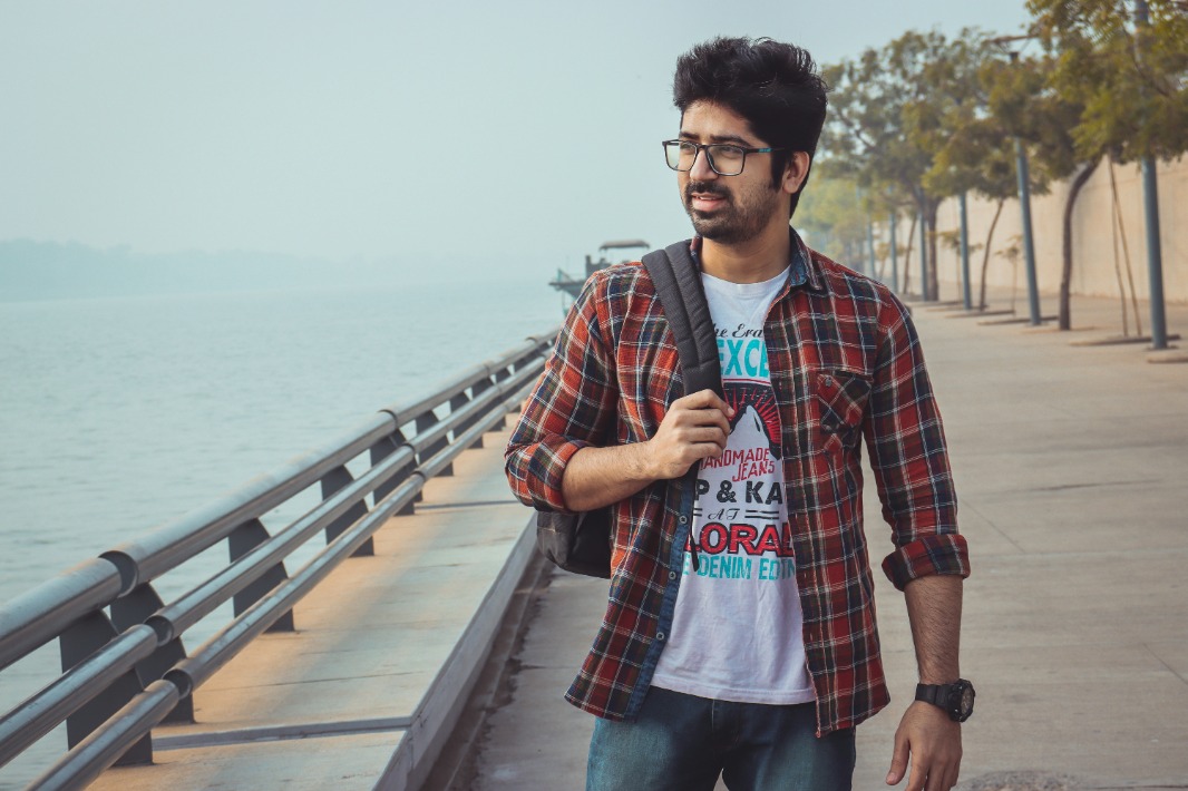 A person standing on a bridge with a scenic background